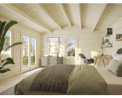 Interiörbild av ett ljust trähus med säng, skrivbord och byrå