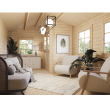 Ljust vardagsrum med träpanel, soffa, fåtöljer och dekorationer för en mysig atmosfär