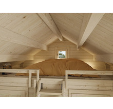 Interiör av ett trähus med säng och takfönster