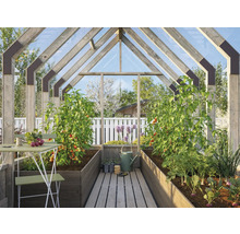 Växthus med växter, bord och stolar för trädgårdsodling