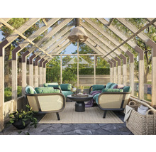 Ljust växthus med sittgrupp, bord och dekoration för utomhusbruk.