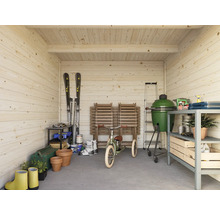 Interiörbild av ett trähus med trädgårdsredskap, grill och skidutrustning