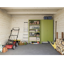 Interiör av ett trädgårdshus i trä med gräsklippare, stege, hylla, skåp och trädgårdsredskap