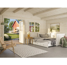 Interiörbild av trähus med säng, fönster och inredning