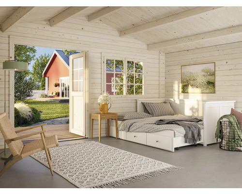 Interiör av ett trähus med säng och utsikt över trädgården