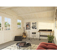 Interiör av ett trädgårdshus i trä med musikinstrument och möbler