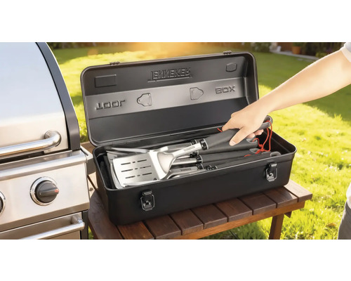 Grillbestickset i en svart förvaringslåda bredvid en grill
