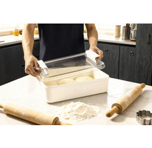 Degbehållare med lock och två kavelar samt mjöl på en köksbänk