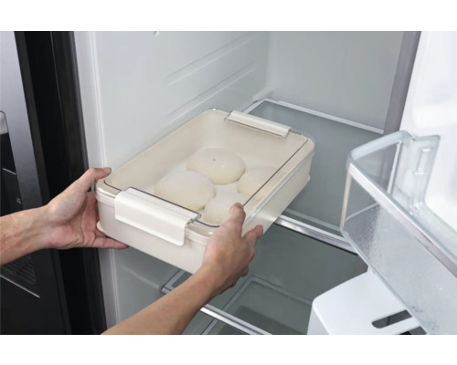 Person ställer en degskål med lock i kylen