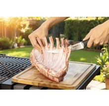 Tillagning av lamminnerfilé på en träbräda med en Tenneker kniv i trädgården.