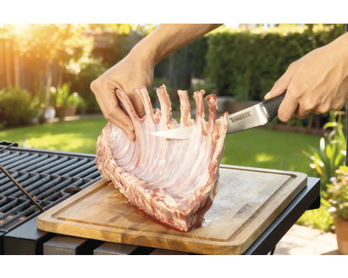 Tillagning av lamminnerfilé på en träbräda med en Tenneker kniv i trädgården.