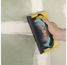 Handslipmaskin som används för att slipa en vägg.