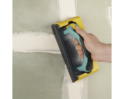 Handslipmaskin som används för att slipa en vägg.