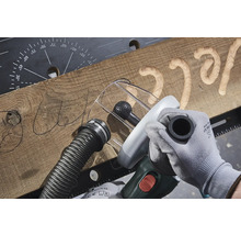 Träbearbetning med ett fräsverktyg för att skapa ett teckensnitt i en träplanka