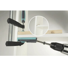 En borrmaskin borrar ett hål i en hylla med hjälp av en borrfixtur.