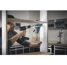 En man monterar en hylla med en sladdlös skruvdragare och en enhandsspännare.