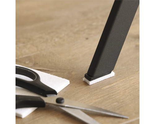 Stolsben med filtplatta, filtplatta och sax på trägolv