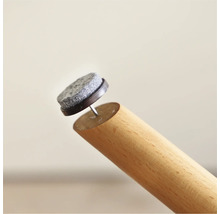 Möbeltass med spik på ett möbelben av trä