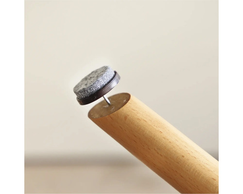 Möbeltass med spik på ett möbelben av trä