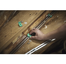 Montering av monteringsvinklar med skruvar och brickor på en metallskena på träunderlag