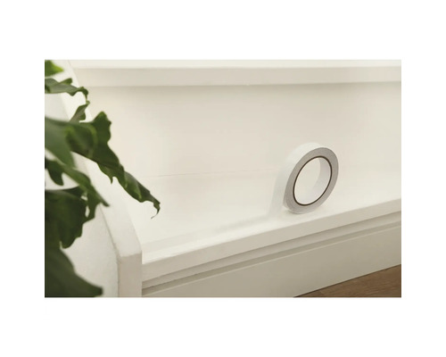 En rulle dubbelhäftande tejp på en yta.