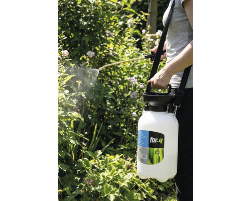 En person använder en for_q trädgårdsspruta för att spruta växter.