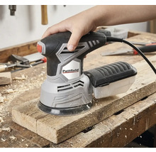 En hand använder en Pattfield excenterslipmaskin på en träplanka.