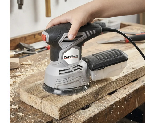 En hand använder en Pattfield excenterslipmaskin på en träplanka.