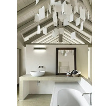 Ljust badrum med sluttande tak, handfat, spegel och badkar