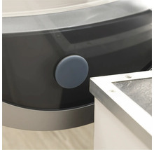 Detalj av en tvättmaskin med en rund, grå tätningsplugg