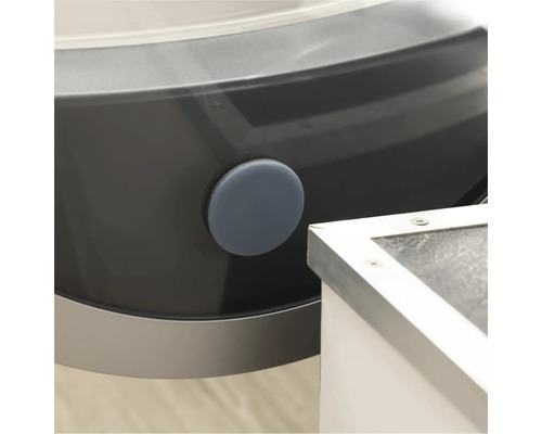 Detalj av en tvättmaskin med en rund, grå tätningsplugg