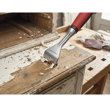 Träskrapa tar bort färg från en trämöbel