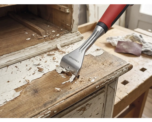 Träskrapa tar bort färg från en trämöbel