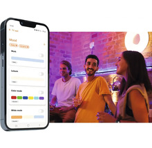 Smartphone med öppen app för ljusstyrning bredvid en upplyst bar med människor