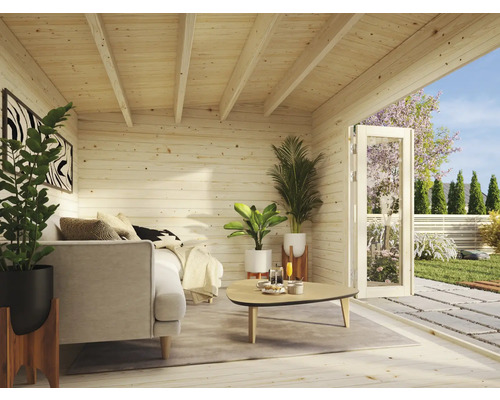 Interiörbild av ett trädgårdshus i trä med soffa, växter och en öppen dörr till trädgården