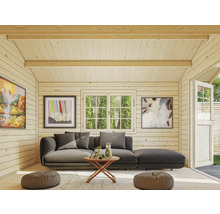 Interiörbild av ett trädgårdshus med soffa, bord, fönster och dekorationer.