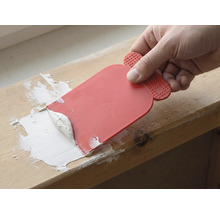 Hantverkare använder en spackel för att applicera fogmassa.