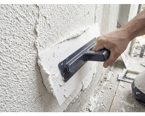 Hantverkare applicerar gips på en vägg med en murslev.