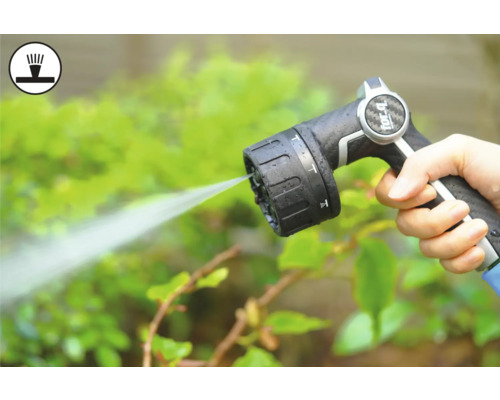 Hand håller trädgårdsslangsprutpistol medan du vattnar växter