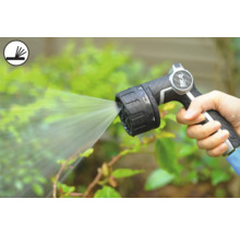 Person håller i en trädgårdsspruta som sprutar vatten