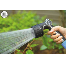 Hand håller trädgårdsspruta vid vattning