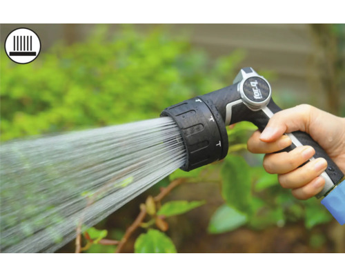 Hand håller trädgårdsspruta vid vattning