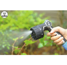 Hand som håller trädgårdsspruta med stråle