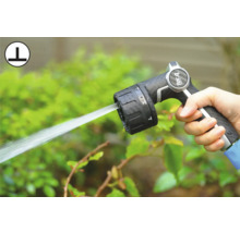 Hand håller trädgårdsslangsprutpistol med justerbara sprutlägen.