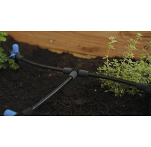 Bevattningssystem med slangar och kopplingar i en trädgårdsbädd