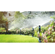 Bevattningssystem i trädgården med grässpridare i drift