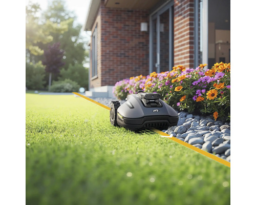 Robotgräsklippare på gräsmatta framför huset