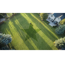 Flygbild av en trädgård med gräsklippare och stjärnmönster i gräsmattan