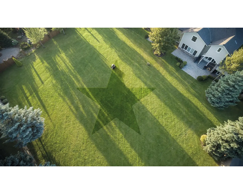 Flygbild av en trädgård med gräsklippare och stjärnmönster i gräsmattan