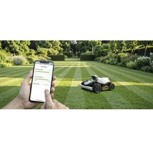 Scen med en robotgräsklippare på en gräsmatta och en person som använder en smartphone för att styra enheten